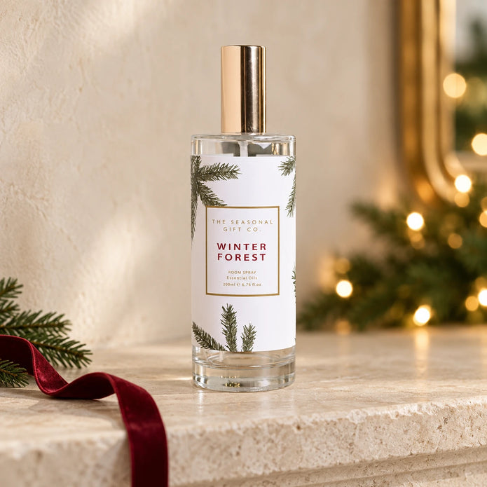 Pine Pattern Winter Forest room spray on a stone mantel with burgundy ribbon and festive greenery.