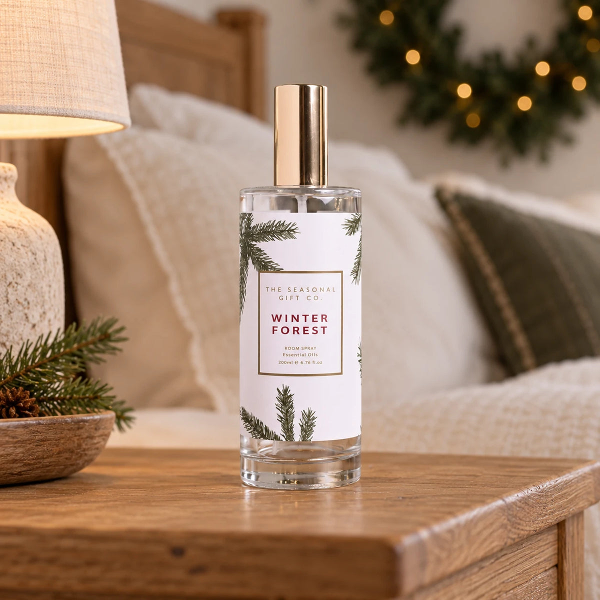 Pine Pattern Winter Forest room spray on an oak bedside table in a cosy country bedroom.
