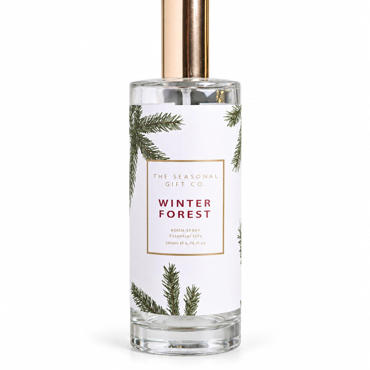 Close view of the pine-patterned Winter Forest label and clear glass bottle on a white background.