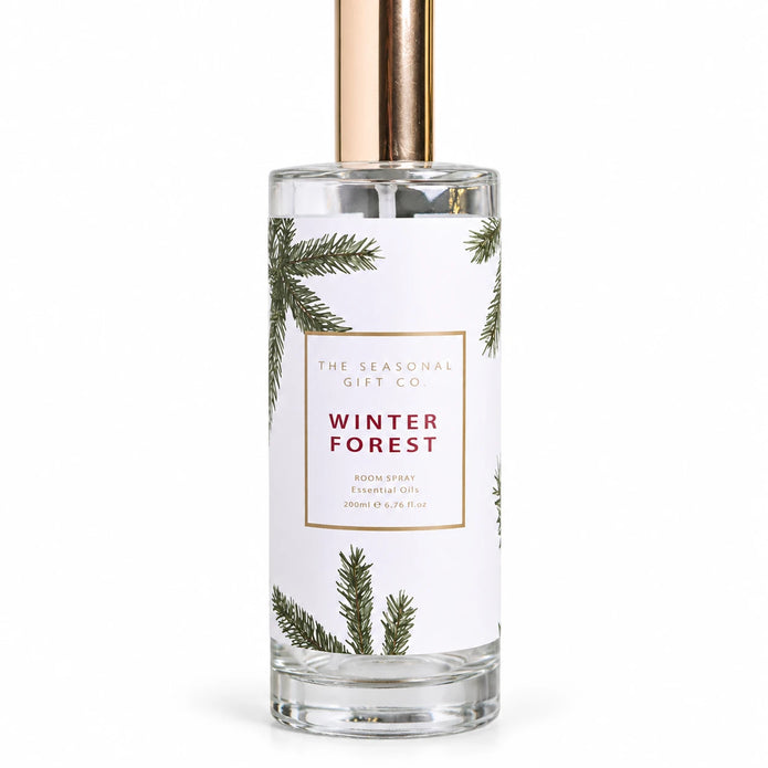 Close view of the pine-patterned Winter Forest label and clear glass bottle on a white background.