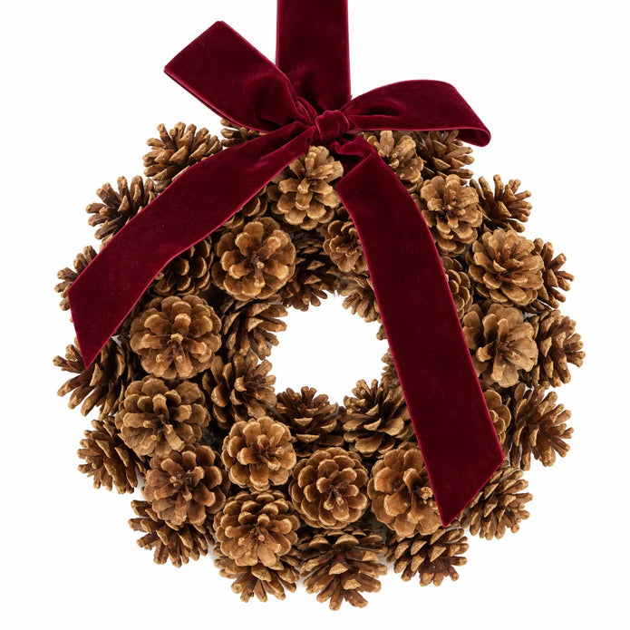 Close-up of pinecone scales and burgundy velvet bow on the Christmas wreath