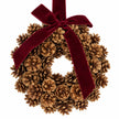 Close-up of pinecone scales and burgundy velvet bow on the Christmas wreath