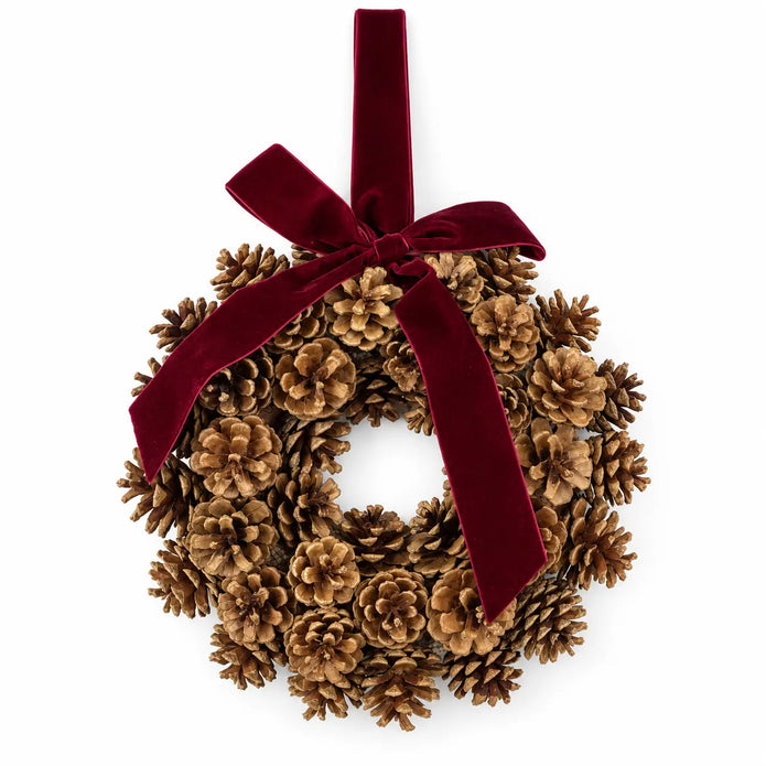 Pinecone wreath with burgundy velvet bow and hanging ribbon on a white background