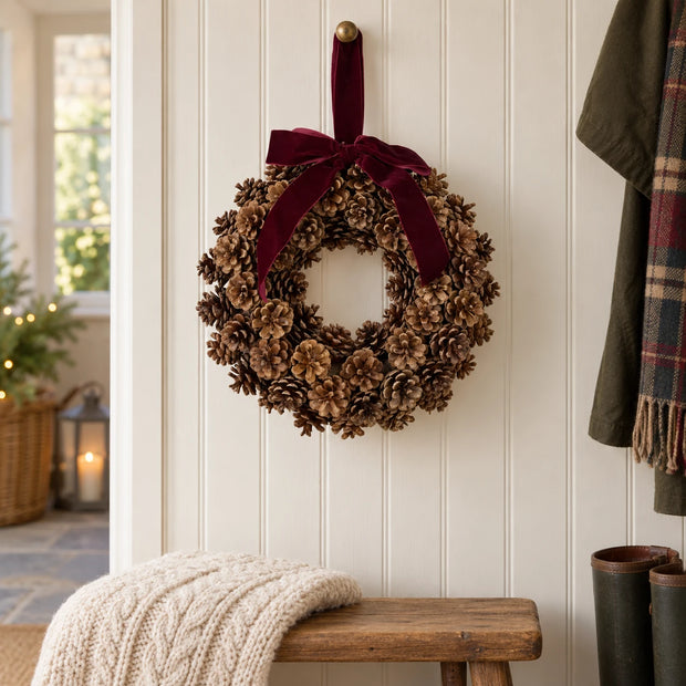 Satchville Christmas pinecone wreath with a decorative bow, ideal for holiday wall decoration.