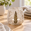 Glass botanical tealight candle holder by Ancient Wisdom, designed for Christmas, with a decorative floral pattern on clear glass.