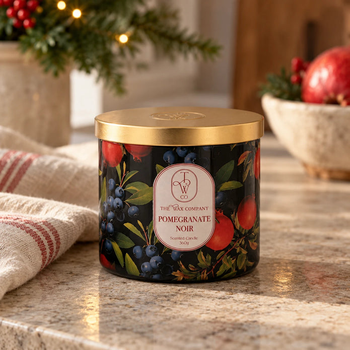 Pomegranate Noir candle with gold lid on a country kitchen counter