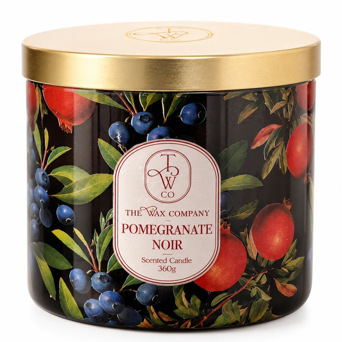 Close view of the Pomegranate Noir candle label, botanical pattern and gold lid