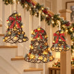 Rattan LED bell set hanging beside a Christmas stair garland