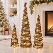 Set of three rattan LED Christmas trees beside a cream fireplace