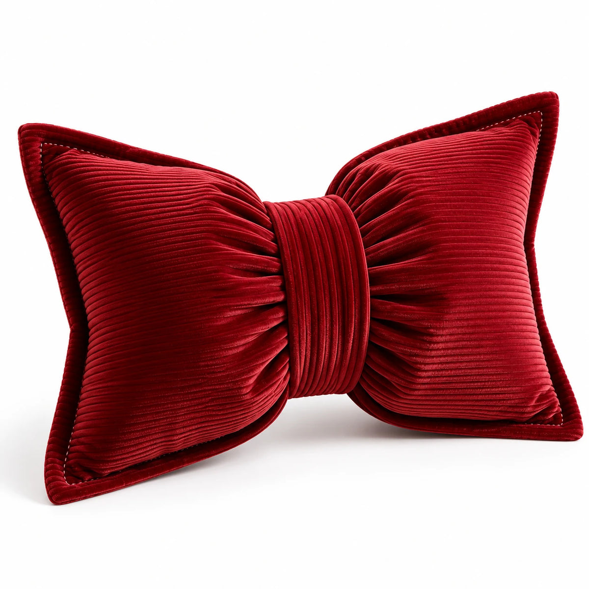 Angled studio view of the red bow cushion showing ribbed corduroy, gathered lobes and matching centre band.