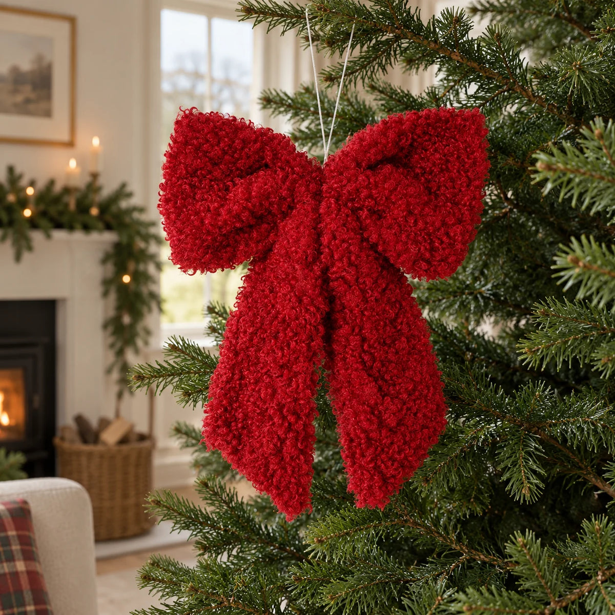Red fluffy bow hanging for Christmas decor, styled on a white background by Heaven Sends.