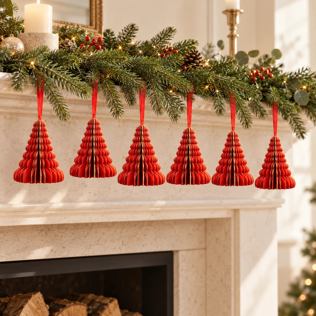 Six red paper Christmas trees suspended beneath a festive mantel garland.
