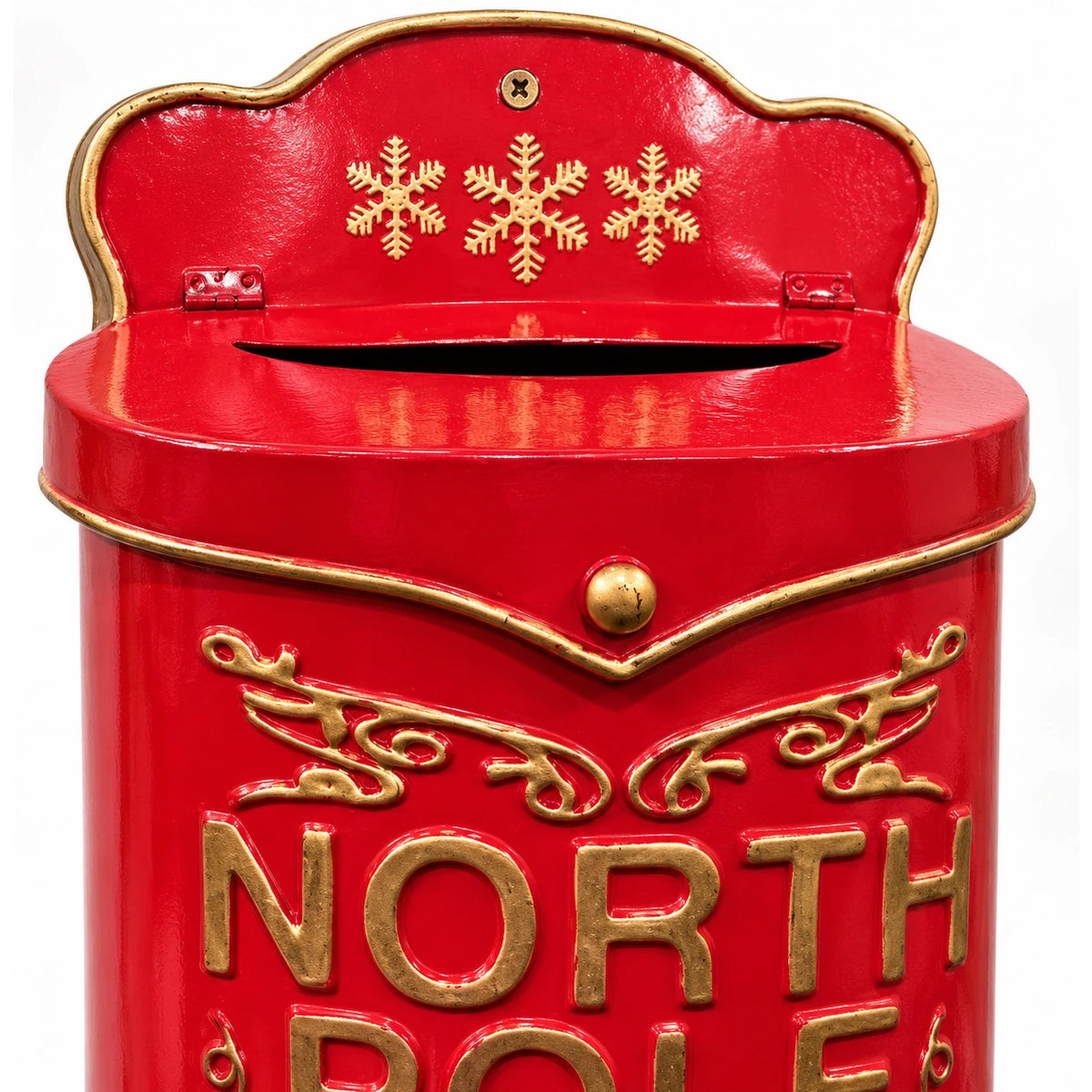 Close-up of the red metal Christmas letterbox showing three gold snowflakes, the letter slot, brass knob and raised gold lettering.