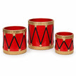 Set of three empty red metal toy drum planters with gold rims on a white studio background.