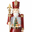 Close-up of red nutcracker snow globe showing gold detailing and miniature Christmas tree scene