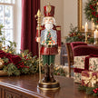 Red nutcracker LED snow globe on a dark oak sideboard with burgundy Christmas decorations