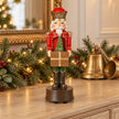 Red musical soldier Christmas decoration styled on oak console with bells