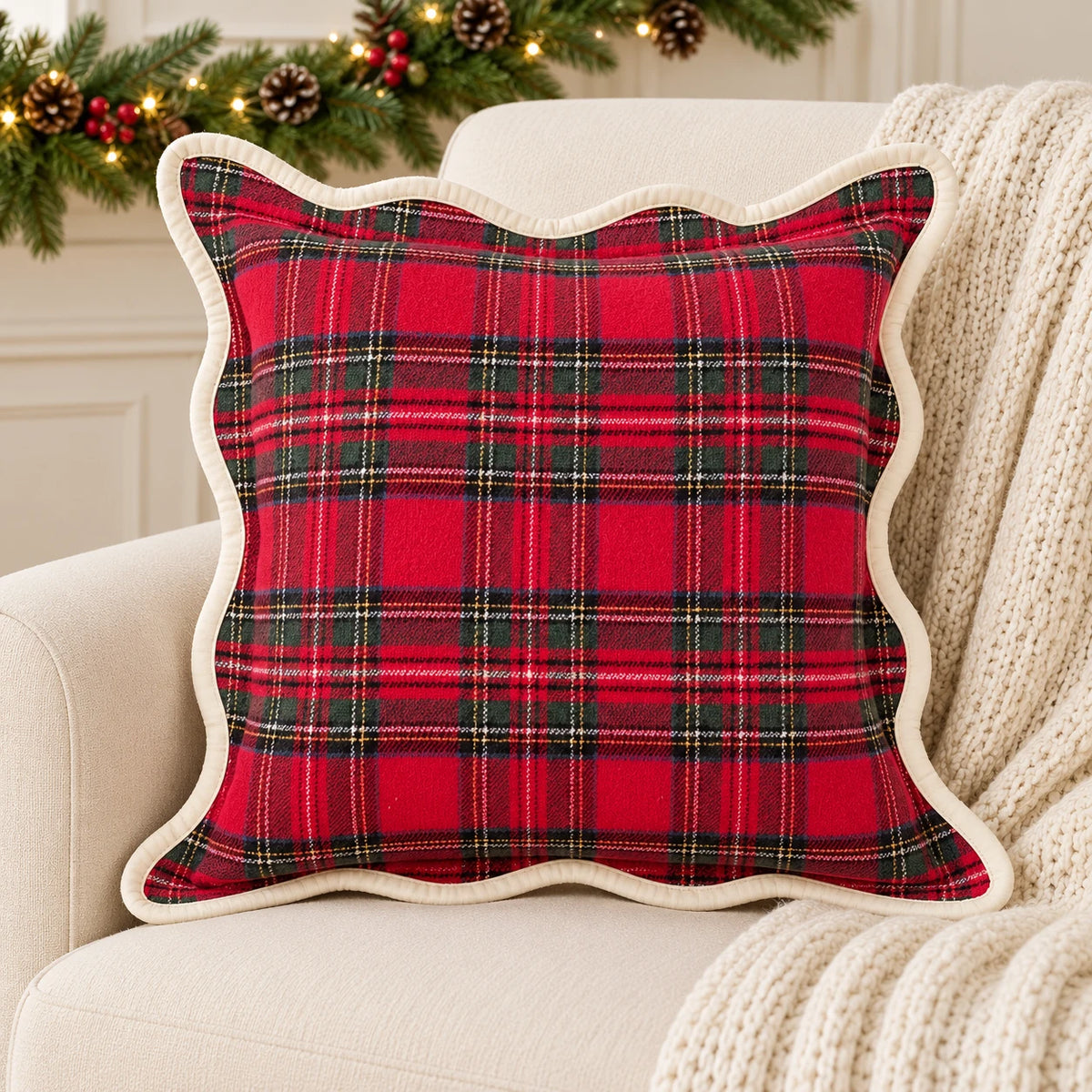 Red and green tartan cushion cover on a cream armchair with festive greenery