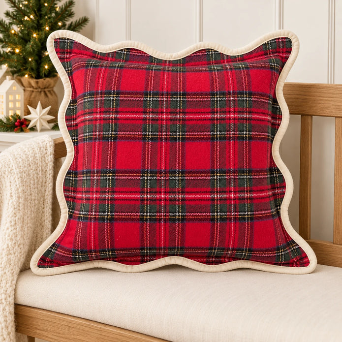 Scalloped red tartan cushion cover on an oak bench with neutral Christmas decorations