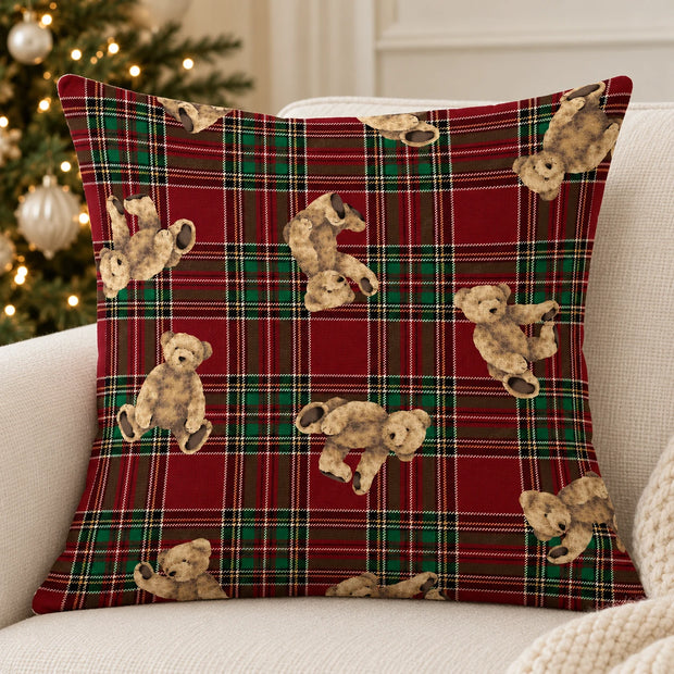 Red tartan teddy bear cushion cover on a cream sofa beside a decorated Christmas tree
