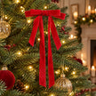 Red long-tail velvet Christmas bow styled on a warmly lit Christmas tree