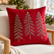 Red velvet cushion cover with three metallic embroidered trees, shown filled on an oak armchair