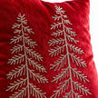 Close-up of fine metallic tree embroidery and soft red velvet cushion-cover texture