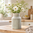 Ribbed metal vase by Satchville with cottage flowers, featuring a textured design for rustic home decor.