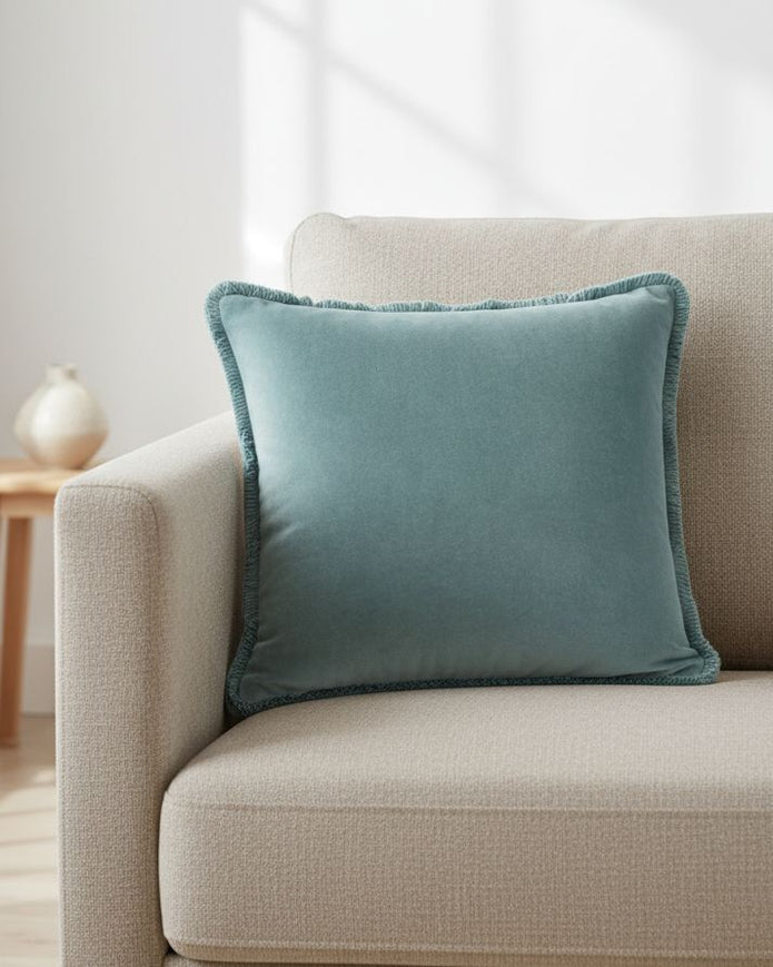 Velvet cushion cover in duck egg blue with Riva Home branding, featuring soft fabric and elegant design for cozy home decor.