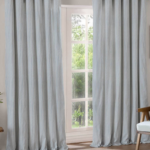 Ocean blue striped blackout eyelet curtains by Riva Home, soft furnishings, showing the fabric with bold blue and black stripes.
