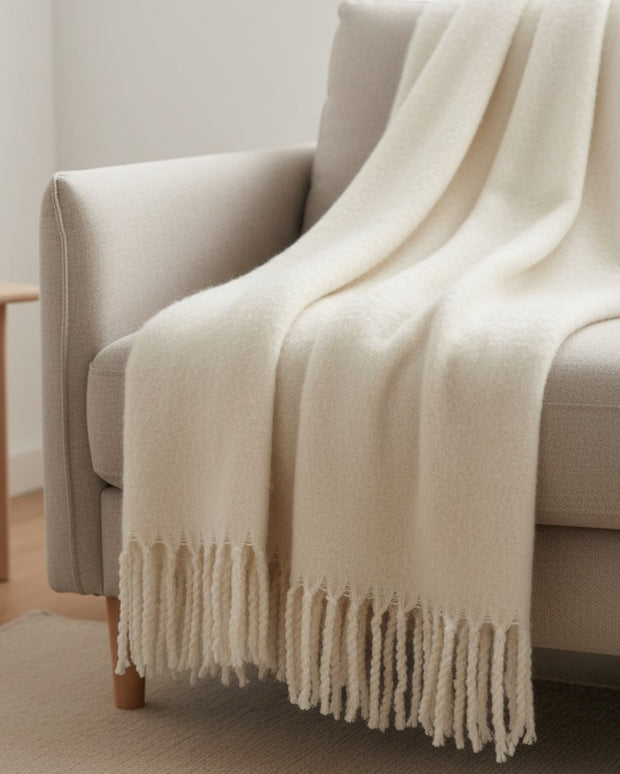 Neutral cream beige fluffy throw blanket from Riva Home, soft and cozy for living room or bedroom decor.