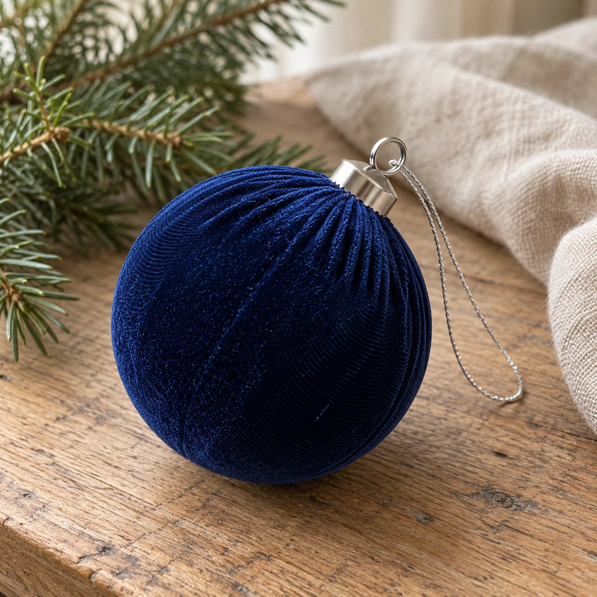 Royal blue velvet Christmas bauble by Starlight Express, hanging on a decorated holiday table with festive decor.