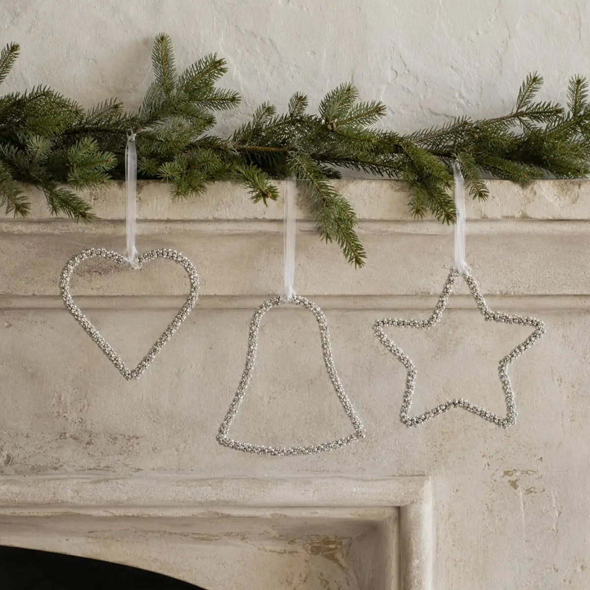 Beaded silver Christmas ornament hanging with intricate bead details, from Heaven Sends for holiday decoration.