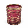 Empty burgundy dotted glass tealight holder with gold rim on white.