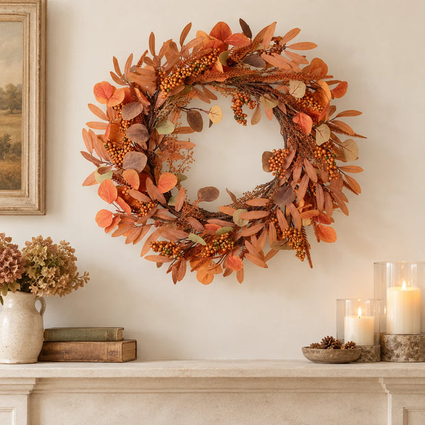 Russet autumn wreath above a cream stone mantel.