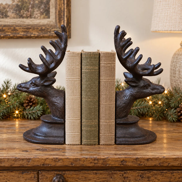 Rust metal reindeer book ends around books on an aged wood console with subtle Christmas greenery.