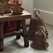 Rustic Brass Coloured Bell, rustic bells grouped beside a wooden stool and armchair