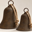 Close-up of the aged metal finish circular top rings and knotted natural jute rope on rustic bells