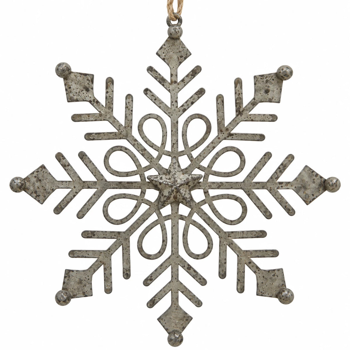 Close-up of distressed metal snowflake with central star and decorative openwork on white.
