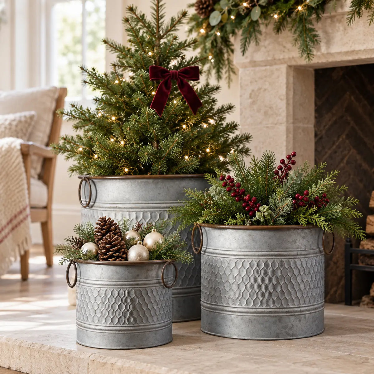 Set of three zinc honeycomb planters with Christmas greenery, berries and baubles beside a cottage fireplace