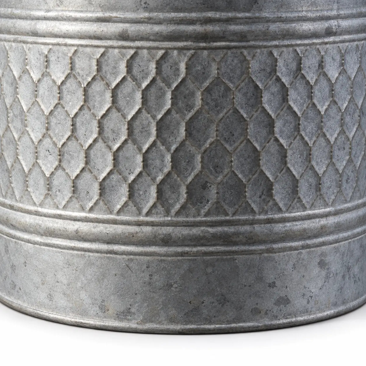 Close-up of embossed honeycomb detailing and mottled grey zinc finish on a metal planter