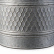 Close-up of embossed honeycomb detailing and mottled grey zinc finish on a metal planter