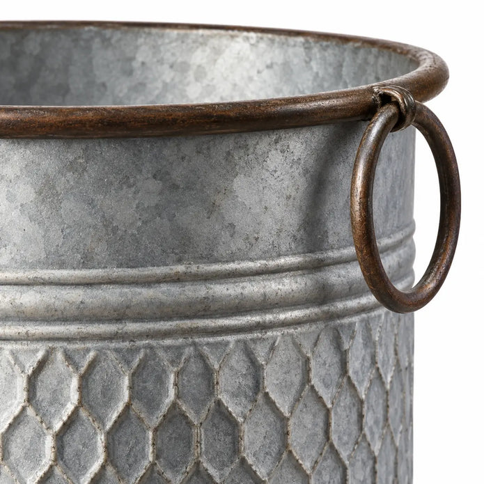 Close-up of the brown ring handle and rolled rim on a rustic zinc honeycomb planter