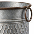 Close-up of the brown ring handle and rolled rim on a rustic zinc honeycomb planter