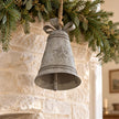 Rustic metal hanging bell with bow on an evergreen garland