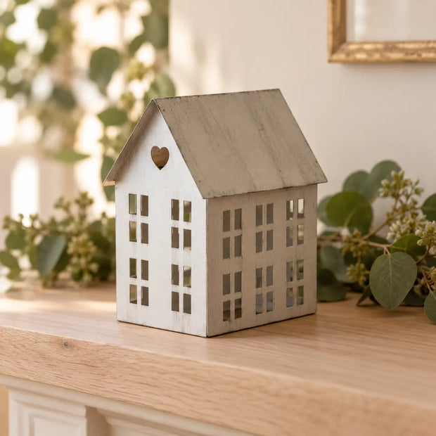Rustic metal tealight house on an oak mantel, shown empty