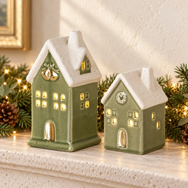 Medium and small sage green LED ceramic houses side by side on a Christmas mantel, showing the two sizes sold individually.