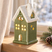 Sage green LED light up ceramic house on winter windowsill