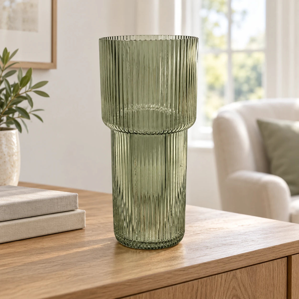 Satchville sage green tall ribbed glass vase on a sideboard, showcasing its elegant, textured design and slender shape.