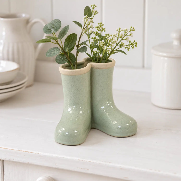 Satchville small sage green ceramic Wellington boot vase with foliage on a dresser